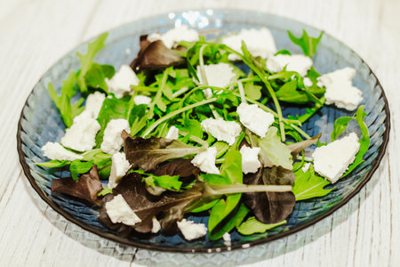 Salad leaves with arugula, cheese, green olives in a plate, healthy diet salad.の写真素材