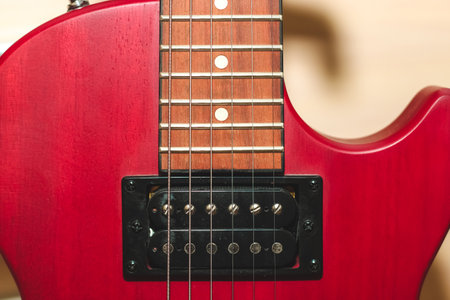 Red electric guitar with strings close up.の写真素材