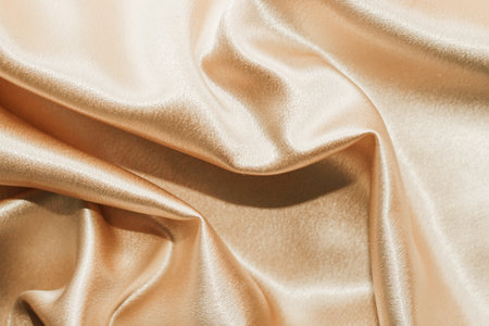 Golden shiny texture of silk satin satin with folds.の写真素材