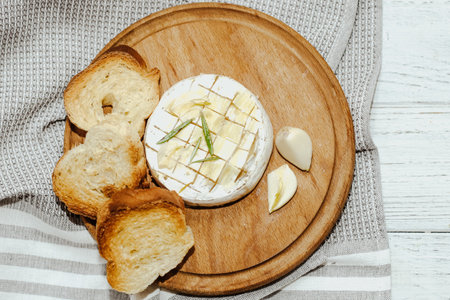 White baguette cut into pieces with olive oil and Camembert cheese on the table.の写真素材