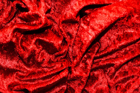 Texture of red velor corduroy fabric with folds.の写真素材