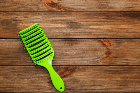 Massage light green hair brush on a wooden background.の写真素材