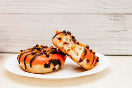 Donuts with icing on a plate on a wooden background.の写真素材