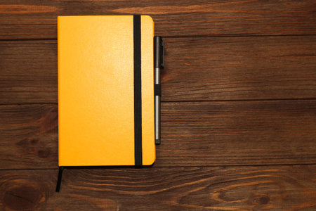 Yellow business diary on a wooden background.の写真素材