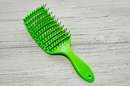 Massage light green hair brush on a wooden background.の写真素材