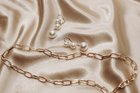 Women's jewelry, gold chain, trendy jewelry on a silk background.の写真素材