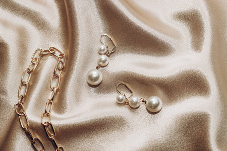 Women's jewelry, gold chain, trendy jewelry on a silk background.の写真素材