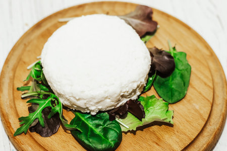 suluguni pickled cheese on a wooden board with herbs.の写真素材