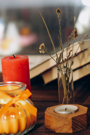 Still life with skins, Orange aroma candle in a figured candlestick with a bow and books on the background.の写真素材