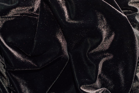 Texture of black velor corduroy fabric with folds.の写真素材