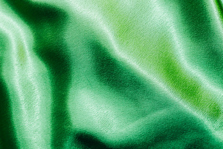 Green shiny texture of silk satin satin with folds.の写真素材