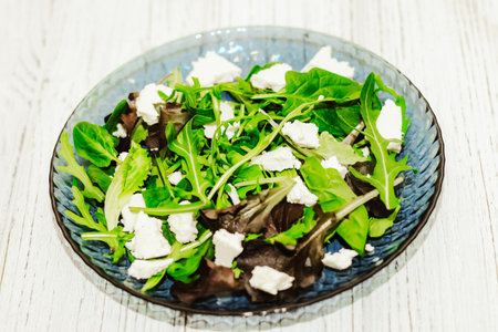 Salad leaves with arugula, cheese, green olives in a plate, healthy diet salad.の写真素材
