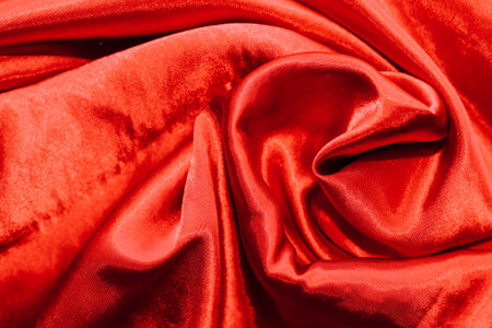 Red shiny texture of silk satin satin with folds.の写真素材