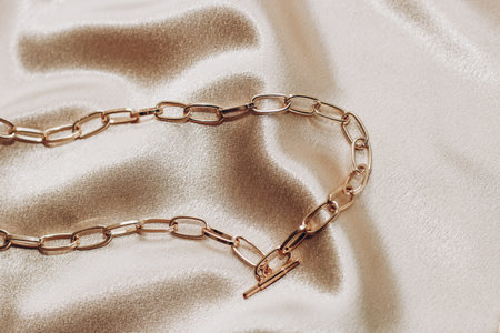 Women's jewelry, gold chain, trendy jewelry on a silk background.の写真素材