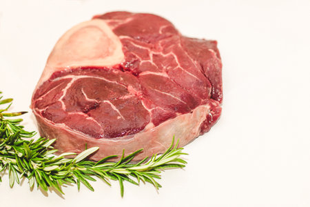 Fresh piece of meat large beef steak on the bone ossobuco with rosemary sprig.の写真素材
