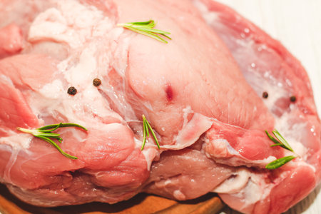 Fresh piece of meat large pork ham on a board with pepper.の写真素材