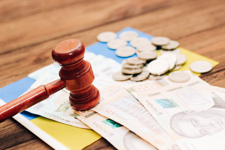 Ukrainian blue yellow flag with judge's gavel and hryvnias on a wooden background.の写真素材