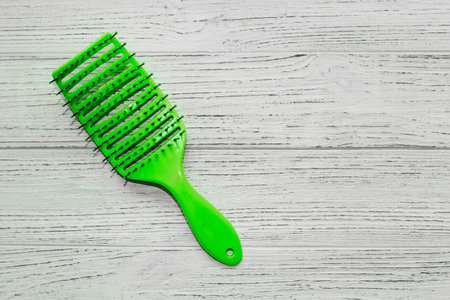 Massage light green hair brush on a wooden background.の写真素材