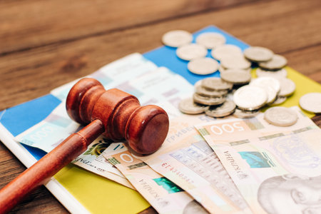 Ukrainian blue yellow flag with judge's gavel and hryvnias on a wooden background.の写真素材