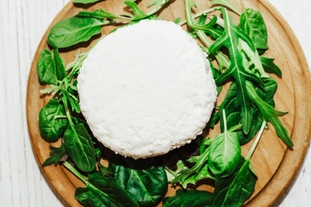 suluguni pickled cheese on a wooden board with herbs.の写真素材