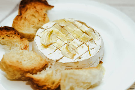 White baguette cut into pieces with olive oil and Camembert cheese on the table.の写真素材
