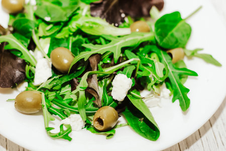 Salad leaves with arugula, cheese, green olives in a plate, healthy diet salad.の写真素材