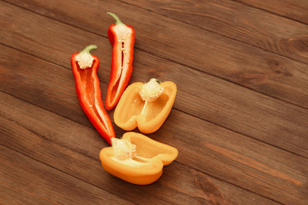 Red pepper Kapi with yellow sweet pepper on a wooden background, space for text.の写真素材