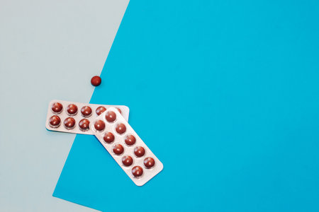 Pills in blister packs of vitamins on a blue background.の写真素材
