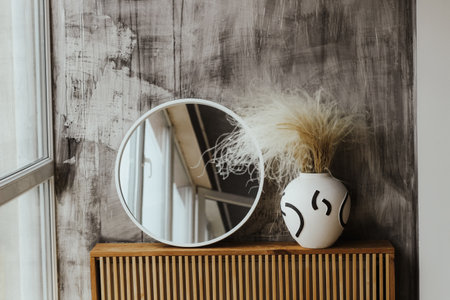 A modern vase with a mirror in a cozy interior.の写真素材