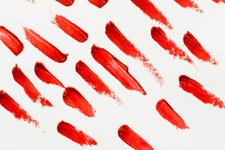 Smears of red cosmetic lipstick on a light background.の写真素材