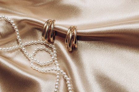 Women's jewelry, gold chain, trendy jewelry on a silk background.の写真素材
