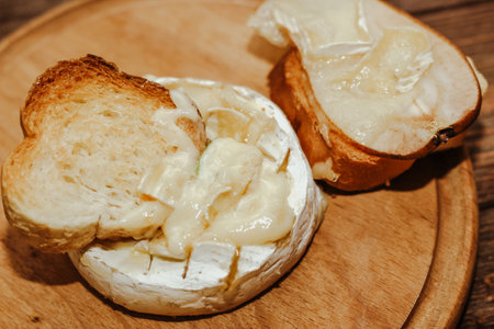 White baguette with olive oil and baked Camembert cheese on the table.の写真素材