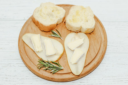 Pieces of ripe pear with Camembert cheese with croutons on the tableの写真素材