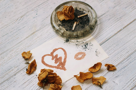 Drawn heart with lipstick on the background of dry roses, separation concept.の写真素材
