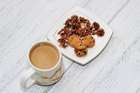 Healthy breakfast oat round granola with nuts on a plate and coffee, seed cookies.の写真素材