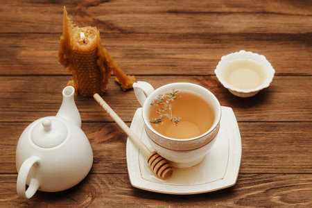 Liquid fresh linden honey in a plate with a wooden honey spoon and tea.の写真素材
