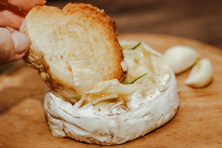 White baguette with olive oil and baked Camembert cheese on the table.の写真素材