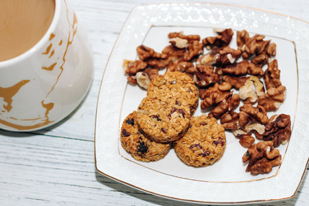 Healthy breakfast oat round granola with nuts on a plate and coffee, seed cookies.の写真素材