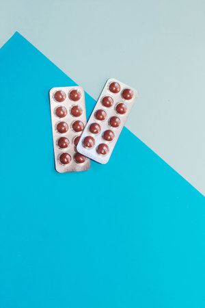 Pills in blister packs of vitamins on a blue background.の写真素材