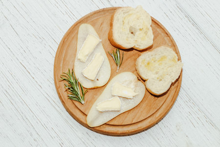 Pieces of ripe pear with Camembert cheese with croutons on the tableの写真素材