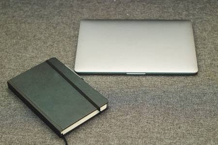 Laptop series flat metal on the table with a business diary.の写真素材
