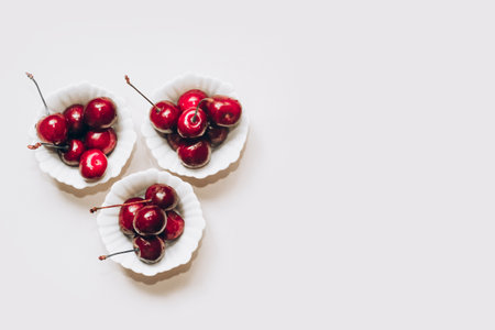 Ripe red cherries in white plates on the table.の写真素材