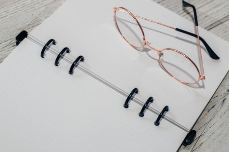 Notebook with rings, checkered sheets, transparent cover with glasses.の写真素材