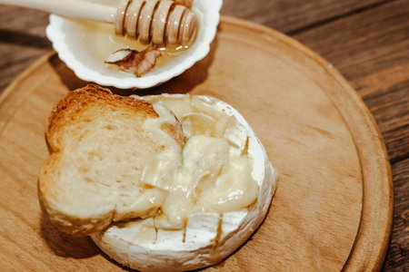 White baguette with olive oil and baked Camembert cheese on the table.の写真素材