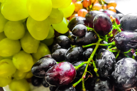 Purple and green grapes on twigs close-up.の写真素材