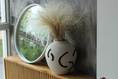 A modern vase with a mirror in a cozy interior.の写真素材