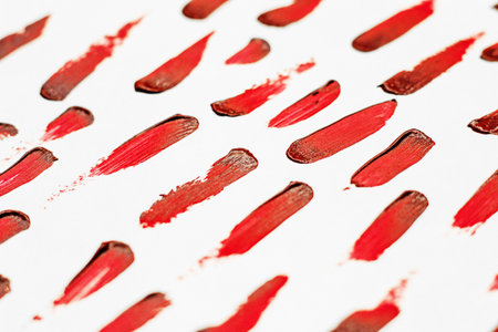 Smears of red cosmetic lipstick on a light background.の写真素材
