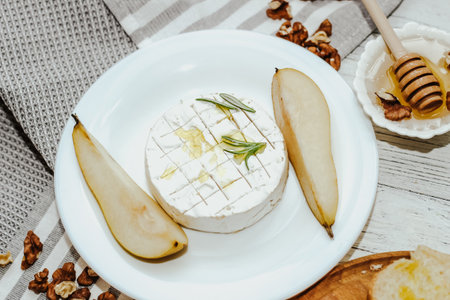 Pieces of ripe pear with Camembert cheese on the table.の写真素材
