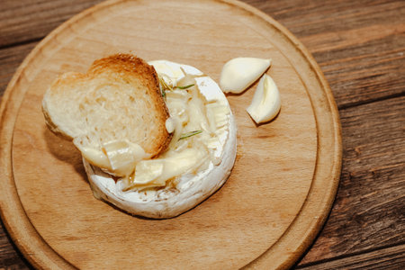 White baguette with olive oil and baked Camembert cheese on the table.の写真素材