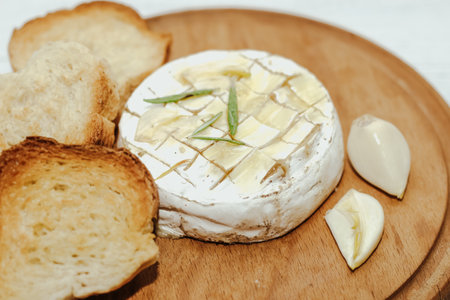 White baguette cut into pieces with olive oil and Camembert cheese on the table.の写真素材